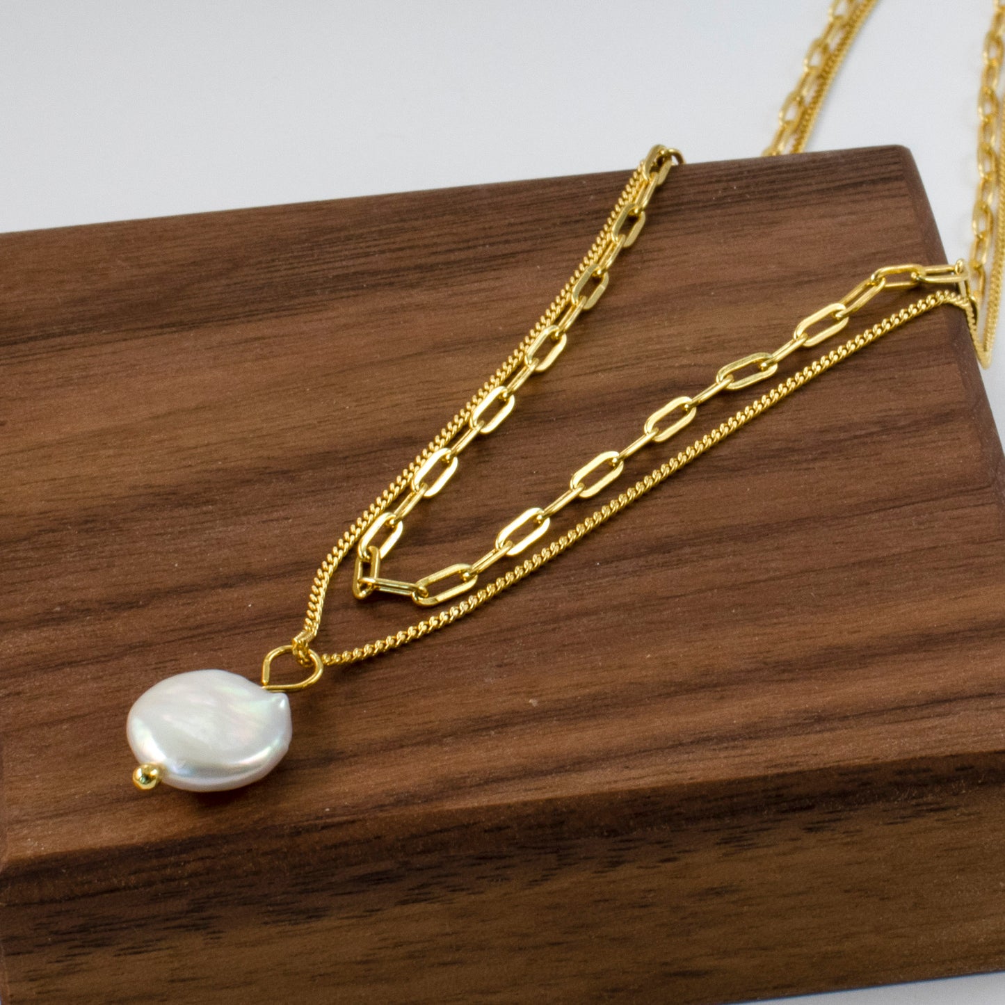 A sizable baroque pearl adorns the double beaded chain of this necklace, radiating simplicity and charm.