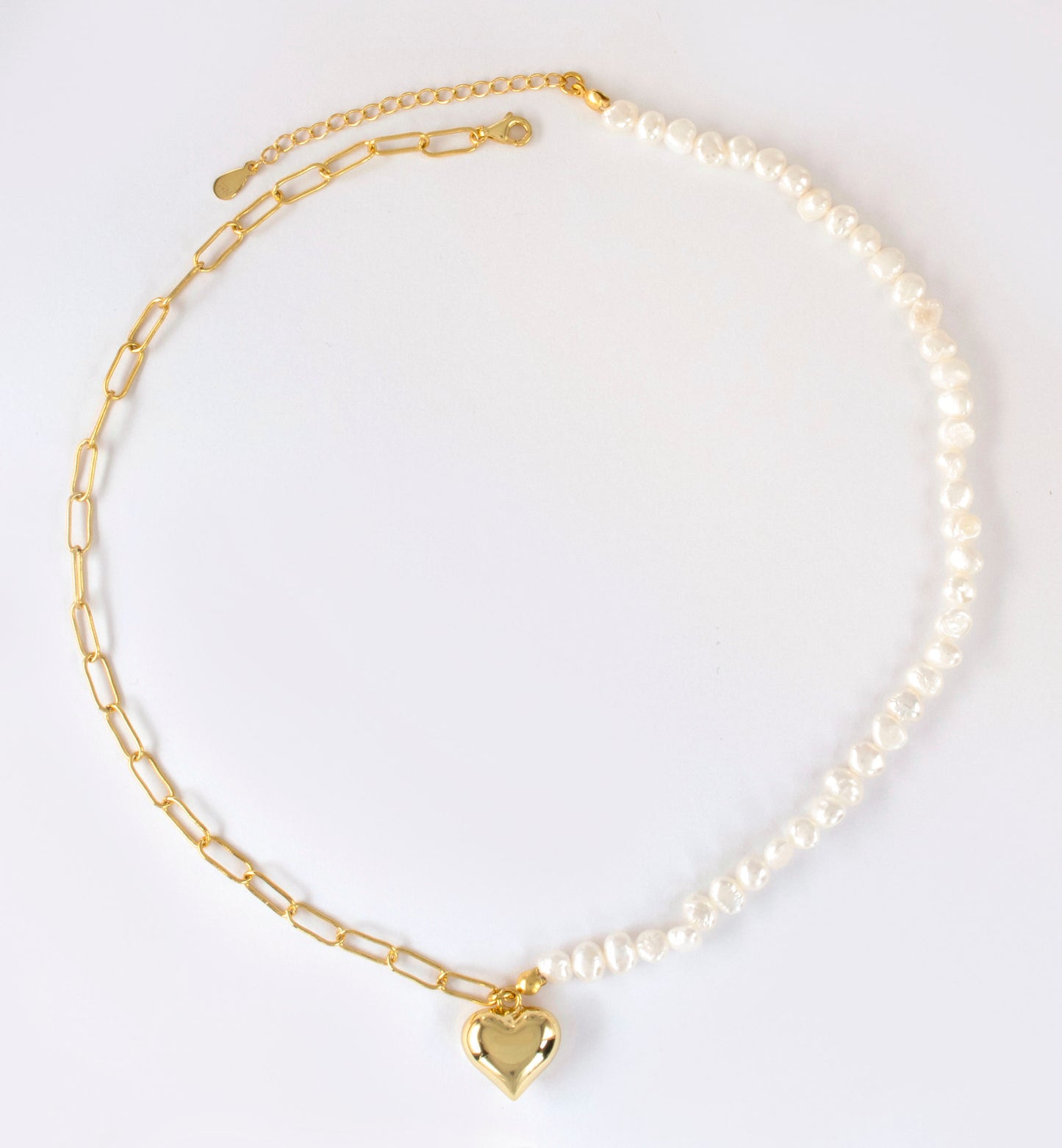This stylish piece features a half chain with baroque pearls and other half an alta chain with a heart pendant.