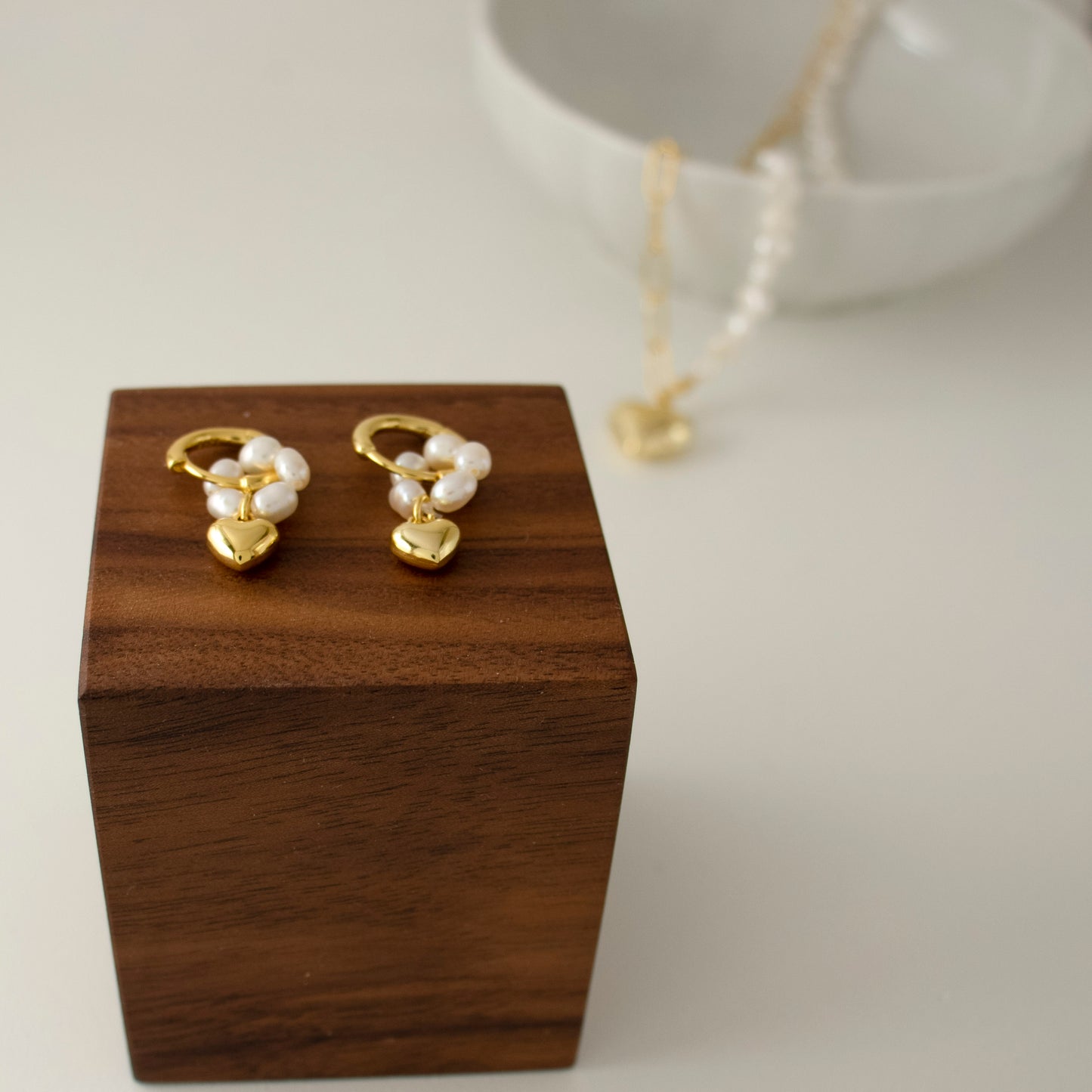 This stylish piece features a pearl-ring with a heart pendant.