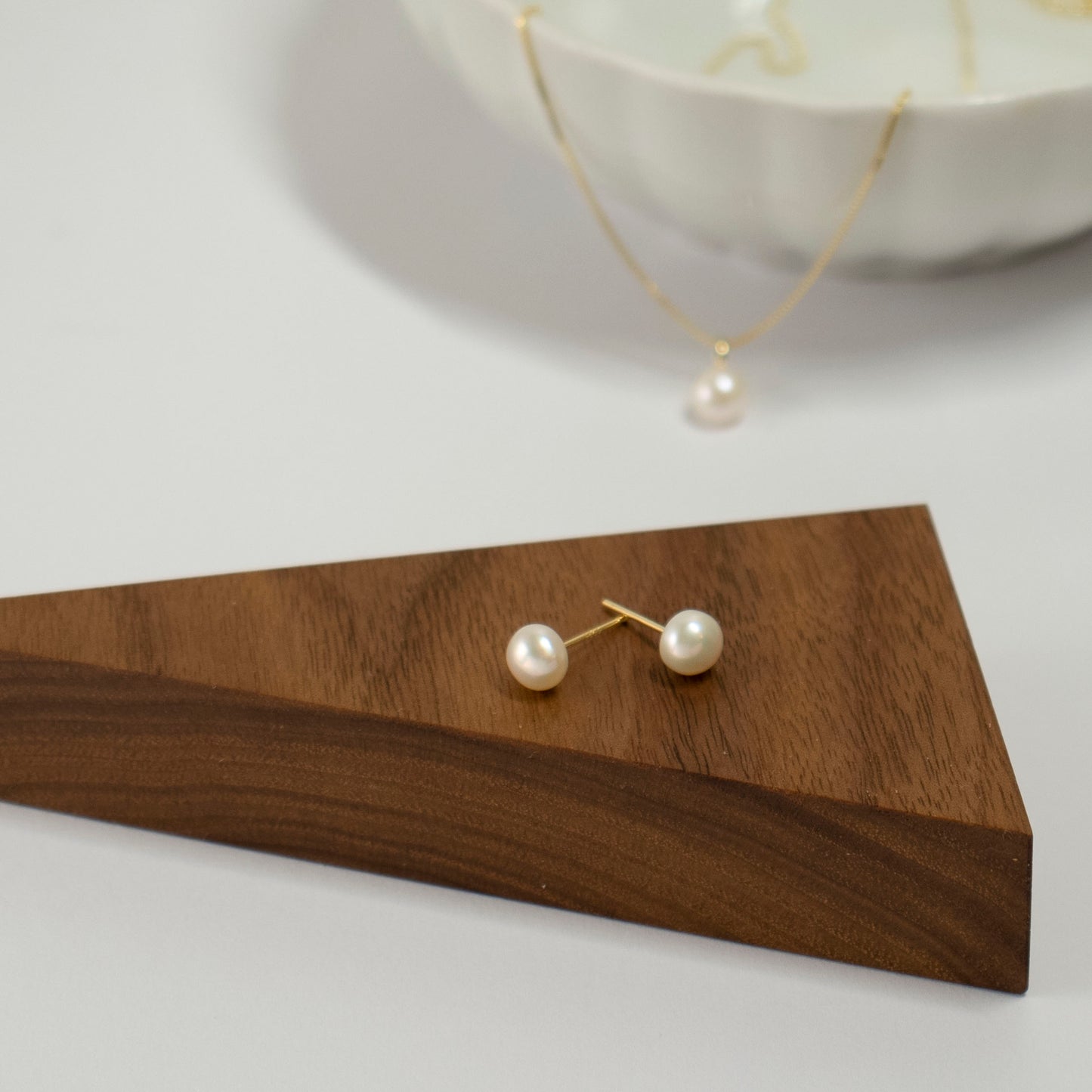 A solitary semi-round pearl adorns the stud.