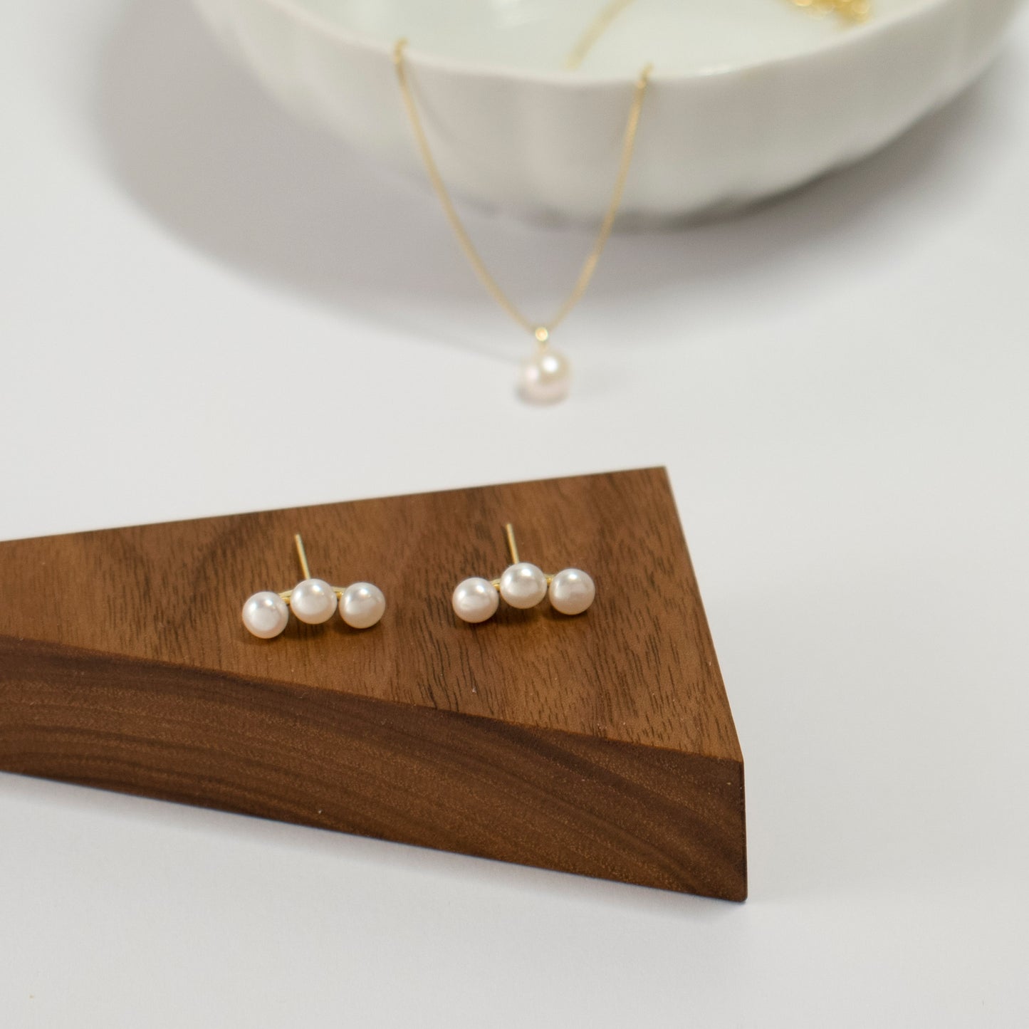 Three freshwater pearls are arranged in an arc on the earrings.