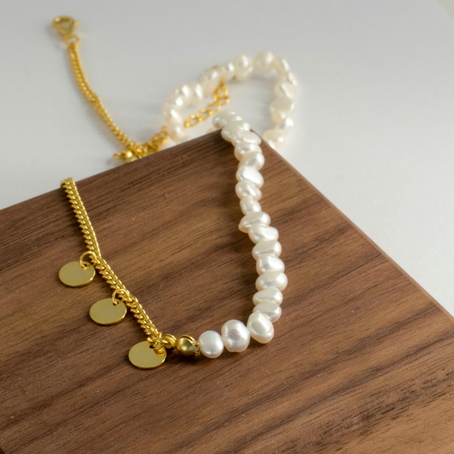 The double-layered necklace is adorned with rice pearl nuggets.