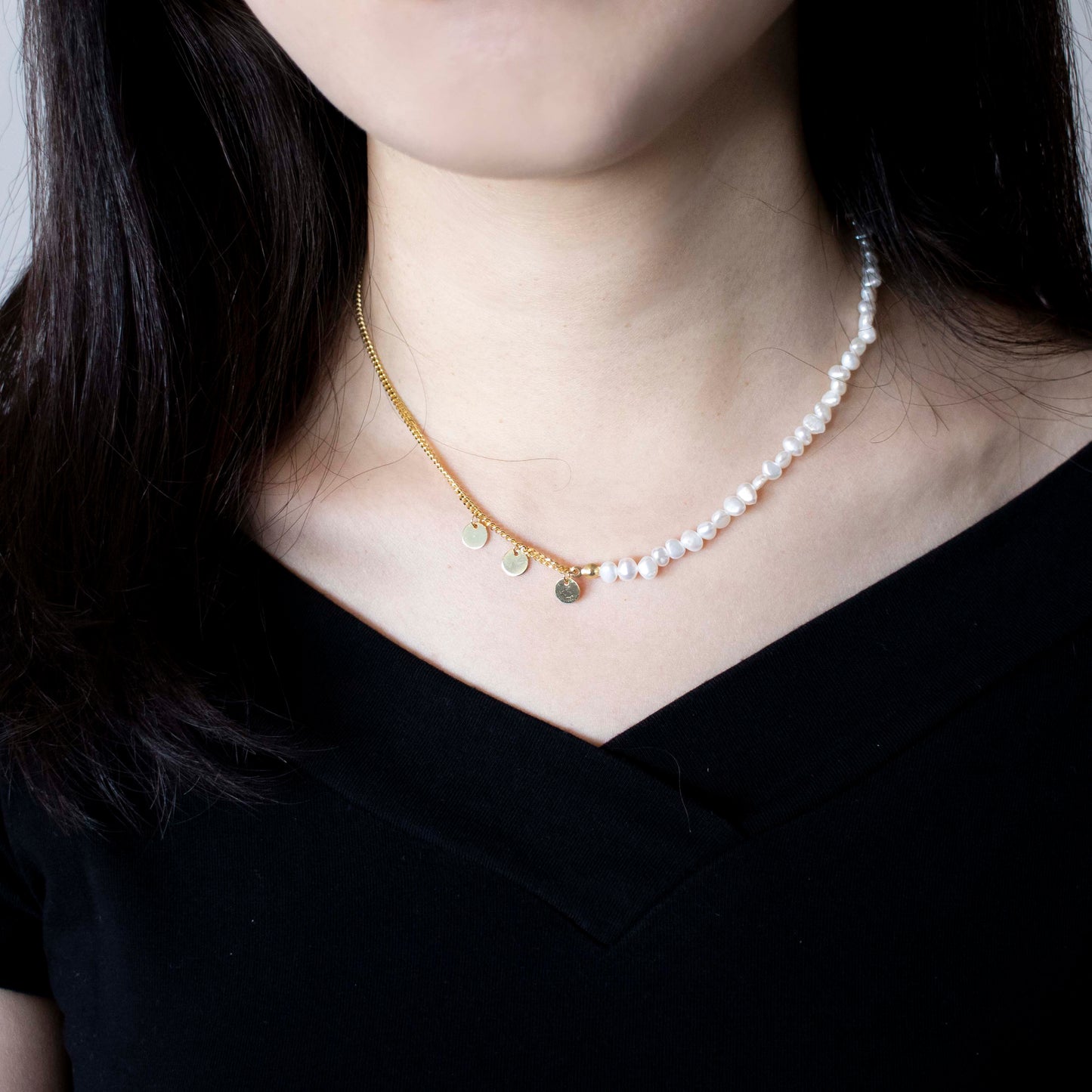 The double-layered necklace is adorned with rice pearl nuggets.