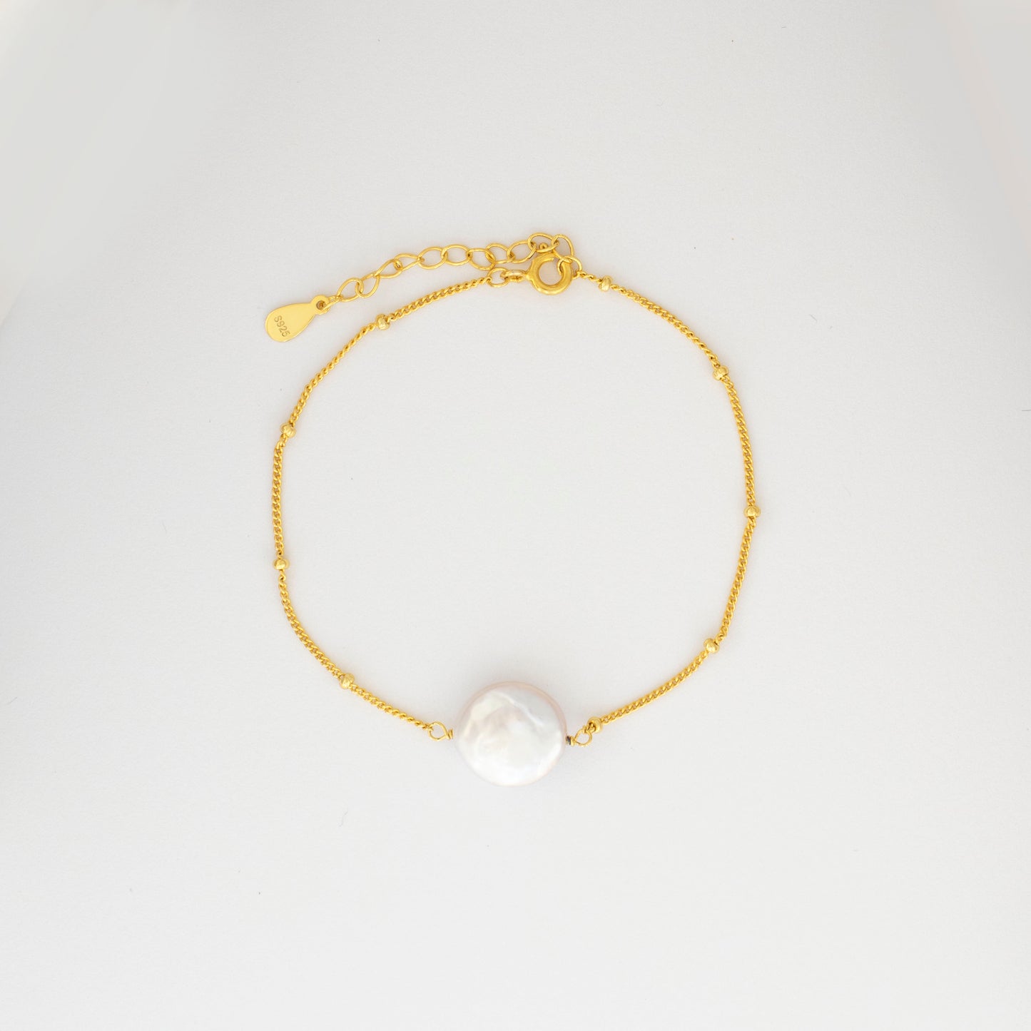 A sizable baroque pearl adorns the delicate beaded chain of this bracelet, radiating simplicity and charm.