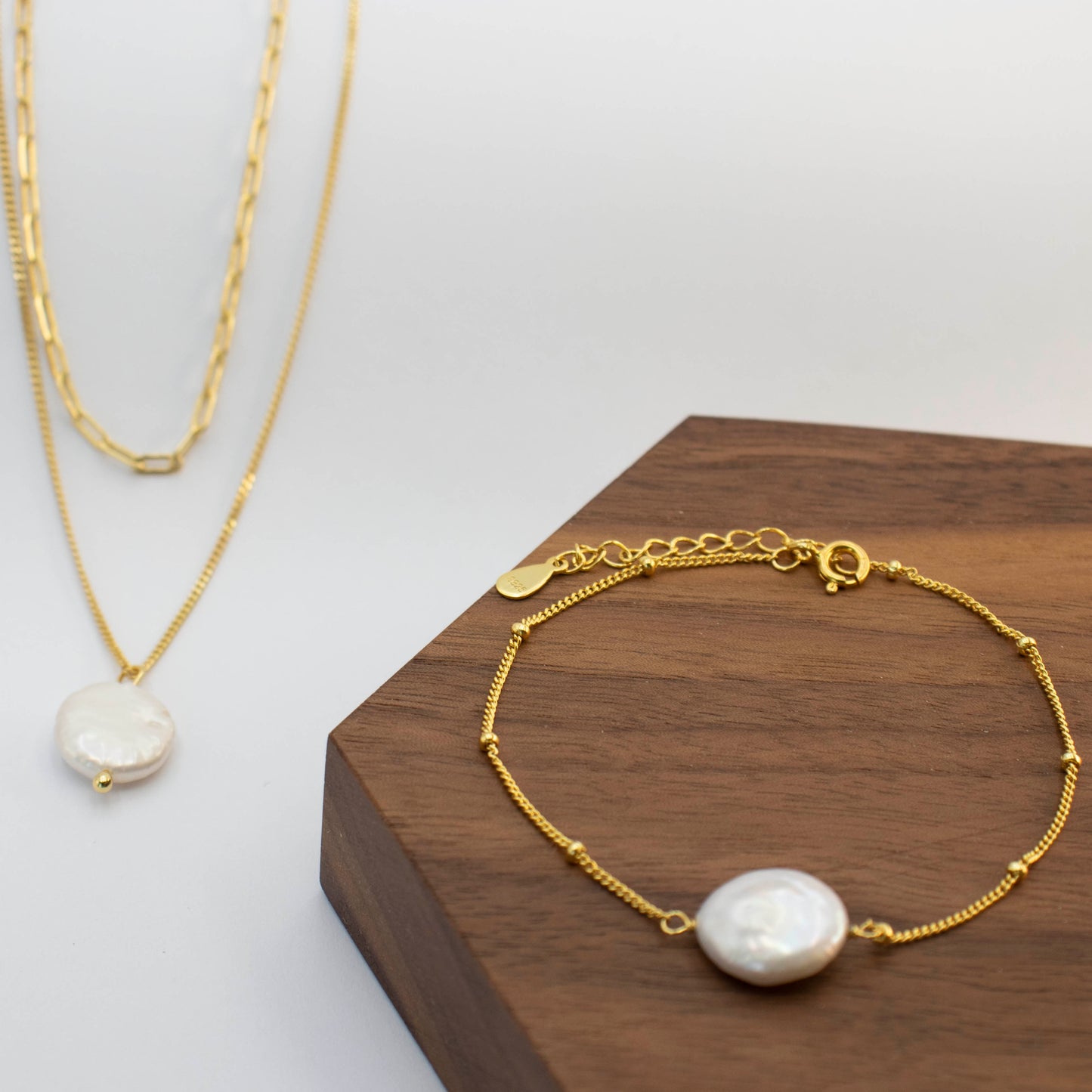 A sizable baroque pearl adorns the double beaded chain of this necklace, with a bracelet in same collection.