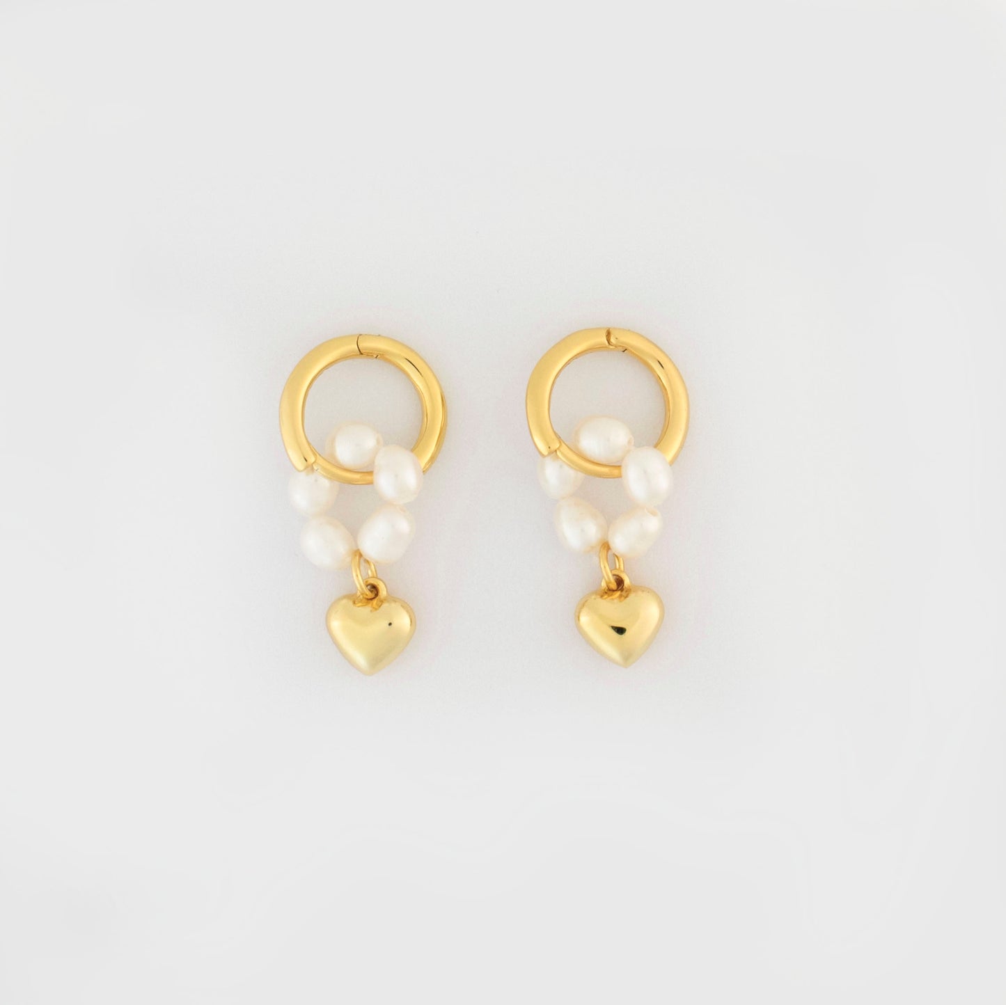 This stylish piece features a pearl-ring with a heart pendant.