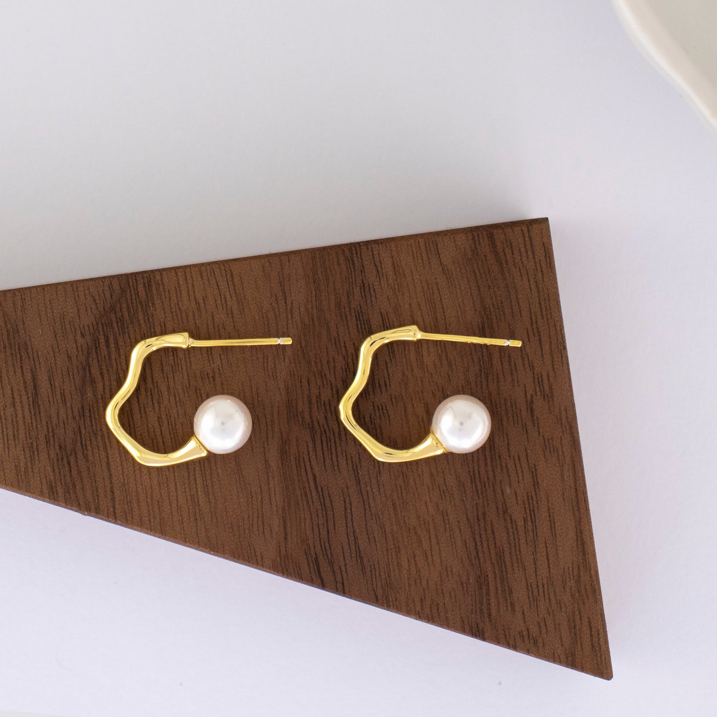 Aquata, lustrous round pearl with an undulating gold stud earrings.