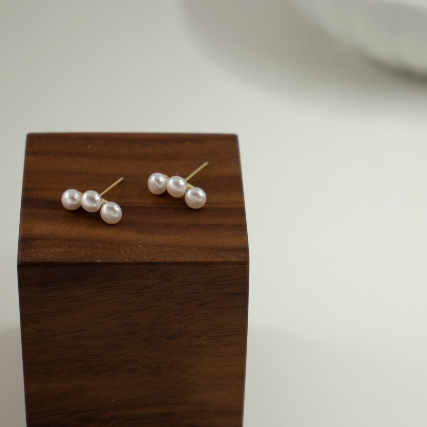 Three freshwater pearls are arranged in an arc on the earrings.
