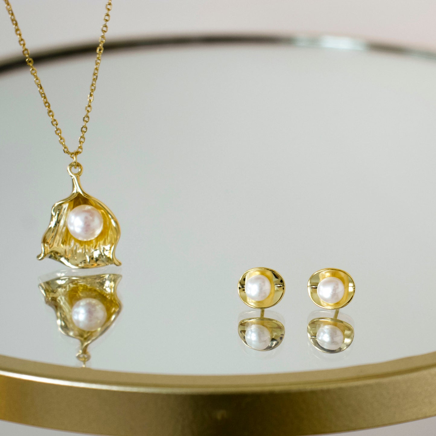 plated in gold, showcase a delightful combination of a shell and a pearl at the center