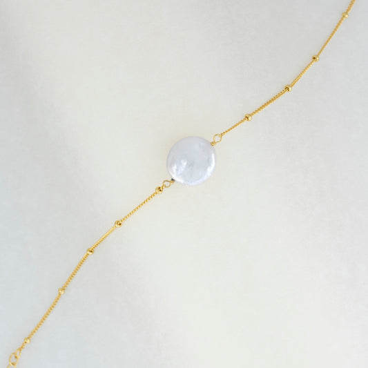 A sizable baroque pearl adorns the delicate beaded chain of this bracelet, radiating simplicity and charm. 